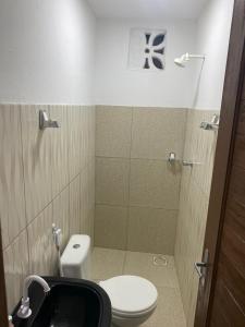 uma pequena casa de banho com WC e chuveiro em Pousada manu em Trairi