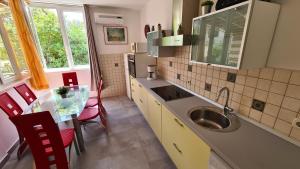 a kitchen with a sink and a table with chairs at Apartments by the sea Brna, Korcula - 9296 in Smokvica