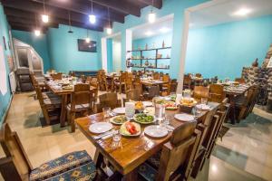 um restaurante com mesas e cadeiras de madeira com comida em Hotel Svaneti em Mestia