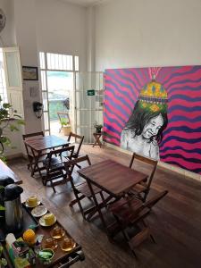 a room with two tables and a painting on the wall at Aldeia Hostel in Manaus