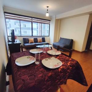Cette chambre comprend une table avec des assiettes et des verres. dans l'établissement Cómodo, acogedor y excelente ubicación en Sopocachi La Paz, à La Paz