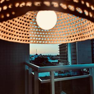 a light on a balcony with a view of a city at Lindo apartamento com vista mar - Aquarius Residence in Fortaleza