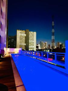 a rooftop swimming pool with a city skyline at night at Lindo apartamento com vista mar - Aquarius Residence in Fortaleza