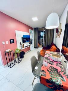 a room with a dining table and a living room at Lindo apartamento com vista mar - Aquarius Residence in Fortaleza