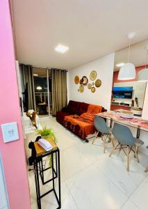 a living room with a couch and a table with chairs at Lindo apartamento com vista mar - Aquarius Residence in Fortaleza