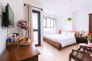 峴港的住宿－Lotus Rock Hotel Đà Nẵng，一间卧室配有一张床和一张桌子及一碗水果