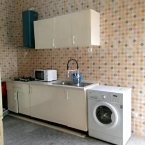 a kitchen with a washing machine and a sink at Appartement baguette du chef in Pointe-Noire