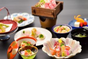 una mesa con platos de comida y tazones de comida en Kansuitei Kozeniya, en Tottori