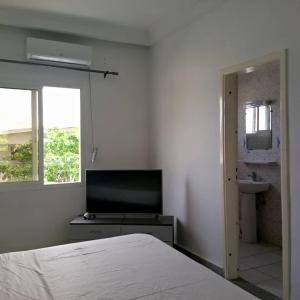 a bedroom with a bed and a flat screen tv at Appartement baguette du chef in Pointe-Noire