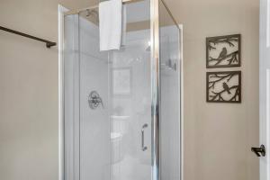 a shower with a glass door in a bathroom at Three Cubs Den - Minutes to PF Strip, Hot Tub, Arcade Games, Bunks, View in Pigeon Forge