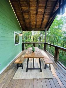 a picnic table on a porch of a house at Three Cubs Den - Minutes to PF Strip, Hot Tub, Arcade Games, Bunks, View in Pigeon Forge
