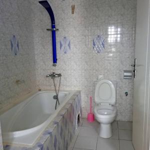 a bathroom with a bath tub and a toilet at Appartement baguette du chef in Pointe-Noire