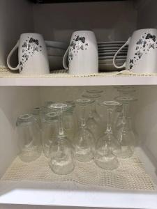 a bunch of wine glasses and cups on a shelf at Munalux 2 bed in Birmingham