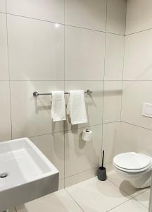 a white bathroom with a sink and a toilet at Mary-B Contemporary Apartment in Windhoek