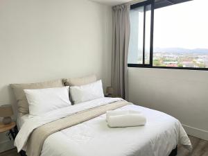 a bedroom with a large white bed with a window at Mary-B Contemporary Apartment in Windhoek