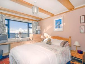 un dormitorio con un osito de peluche sentado en una cama en Brunels Cottage, en Neyland
