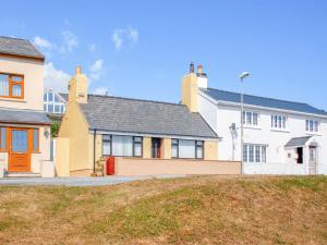 una gran casa blanca con puerta roja en Brunels Cottage, en Neyland