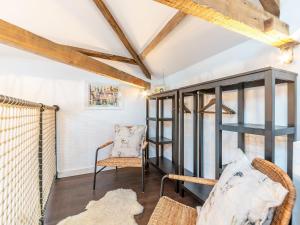 a room with a chair and a book shelf at The Coach House At Orchard Place in Hexham