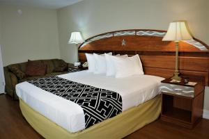 キシミーにあるHotel Monte Carloの大きなベッドとソファが備わるホテルルームです。