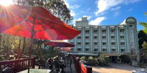 鹿谷的住宿－孟宗山莊大飯店，一座配有红色雨伞和桌椅的建筑