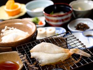 un pedazo de comida sentado en una parrilla con otros alimentos en Kansuitei Kozeniya, en Tottori