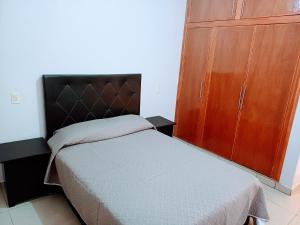 Alojamiento Familiar Varo في Arandas: غرفة نوم بسرير وخزانة خشبية
