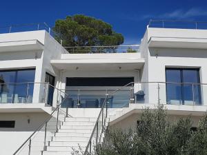 uma casa branca com escadas em frente em Architectural villa with swimming pool em Lorgues