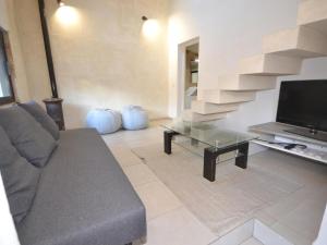 a living room with a couch and a television at Villa with swimming pool within the Luberon in Oppède