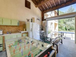a kitchen with a ping pong table in the middle at Villa with swimming pool within the Luberon in Oppède