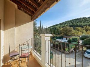 a balcony with two chairs and a table on it at Villa with swimming pool within the Luberon in Oppède