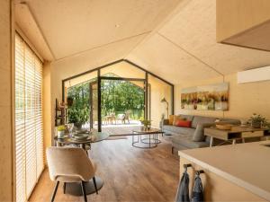 een woonkamer met een bank en een tafel bij Nature house on a beautiful and green domain in Kortgene