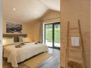 een slaapkamer met een groot bed en een groot raam bij Nature house on a beautiful and green domain in Kortgene