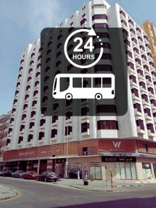 un gran edificio con una señal de autobús. en Wedam Six Al Misfalah فندق ودام ستة, en La Meca