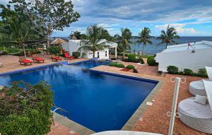 una piscina frente a una casa con el océano en The Gabayan Riviera en Siquijor
