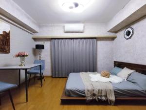 una camera da letto con un letto, un tavolo e una scrivania di B25新宿最中心 新宿站10分-Shinjuku center 10 mins to Station, Max 4 直达新宿 涉谷 表参道 池袋 上野 代代木 银座 原宿 a Tokyo