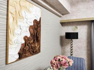 un dipinto su un muro accanto a un tavolo con un fiore di B25新宿最中心 新宿站10分-Shinjuku center 10 mins to Station, Max 4 直达新宿 涉谷 表参道 池袋 上野 代代木 银座 原宿 a Tokyo