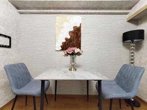 tavolo da pranzo con due sedie e vaso di fiori di B25新宿最中心 新宿站10分-Shinjuku center 10 mins to Station, Max 4 直达新宿 涉谷 表参道 池袋 上野 代代木 银座 原宿 a Tokyo Altre 17 foto