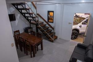 a staircase in a house with a table and a dining room at robiants apartment in Kinatilan