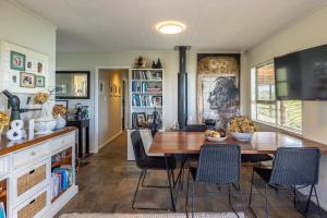 a kitchen and dining room with a table and chairs at Kennedy Point Seascape in Putaki Bay