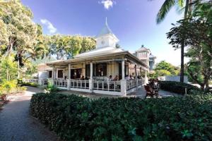 een wit huis met mensen op een veranda bij SeaBreeze Studios ( Room 2 ) - Palm Cove in Palm Cove