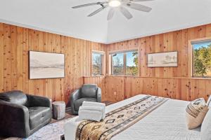 a bedroom with a bed and two chairs and a ceiling fan at Lodge at Mount Rushmore in Keystone