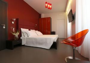 ローマにあるResidenza Crescenzioの赤い壁のベッドルーム1室(ベッド1台付)