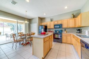 kuchnia z drewnianymi szafkami i jadalnią w obiekcie Family Pool Home, Gated Resort, near Disney & golf -209 w Orlando