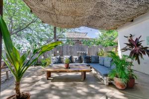 a patio with a blue couch and a wooden table at Popoyo Republic in Popoyo