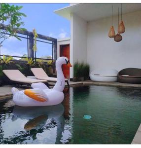 - un flotteur de cygne dans une piscine située dans une maison dans l'établissement VilaDewaScaAcomodation, à Ubud