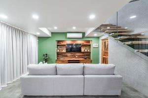 un soggiorno con divano bianco e TV di Tropical Escape Private Pool & Outdoor Kitchen a Sardinal