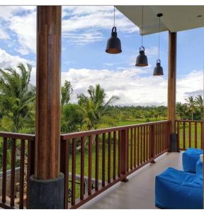 d'un balcon avec deux chaises et une vue sur l'océan. dans l'établissement VilaDewaScaAcomodation, à Ubud