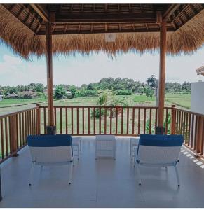 - une table et des chaises sur une terrasse couverte avec vue dans l'établissement VilaDewaScaAcomodation, à Ubud