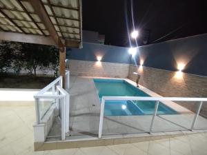 uma piscina à noite com uma pessoa ao lado em Casa e Lazer em Colina de Laranjeiras em Serra
