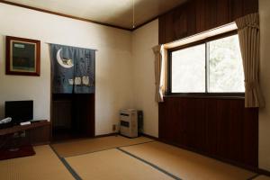 an empty room with a window and a television at Pension FOLKLORE in Suginosawa
